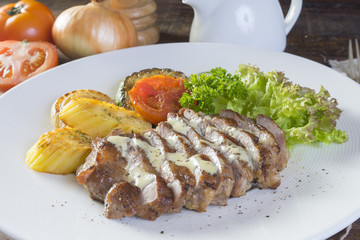 pork steak with vegetable on a white plate