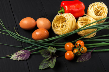 pasta and vegetables on black background