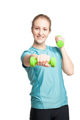 Athletic young woman works out with green dumbbells