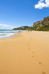 Amazing beach, waves and footsteps at summer time in Corfu island, Greece