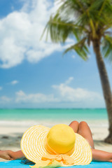 Woman in bikini with sunhat at the beach