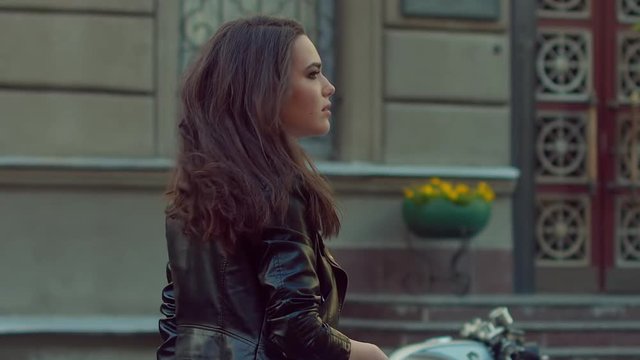 SLO MO MED Urban portrait of a beautiful Caucasian girl. Gorgeous brunette female in leather jacket turning her head, looking for something. 120 FPS 2K HD