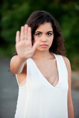 Serious brunette girl making stop sign