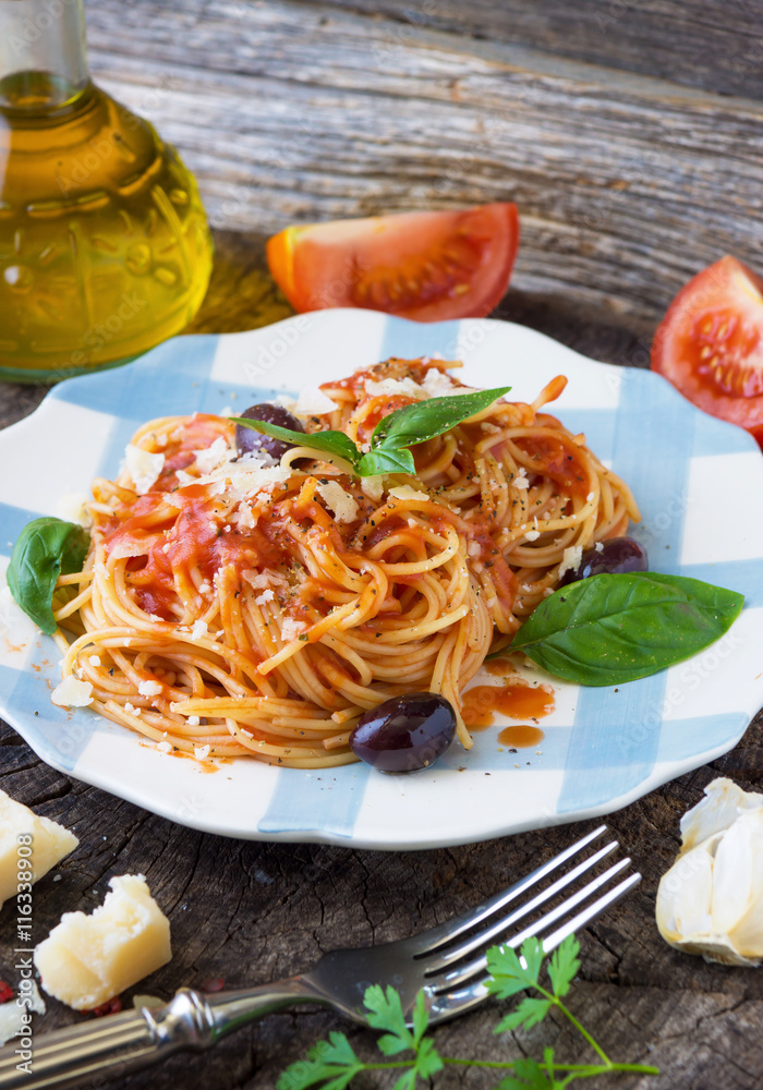 Poster spaghetti with tomato sauce on wooden background