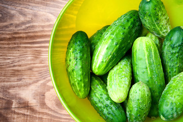 Mini cucumbers in bowl on table
