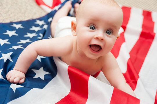 adorable baby girl lying on american flag background