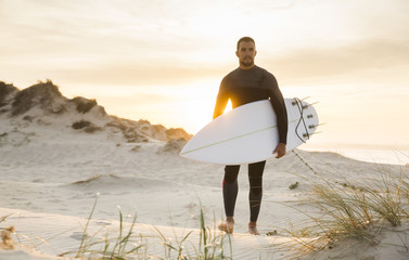 A surfer with his surfboard - obrazy, fototapety, plakaty
