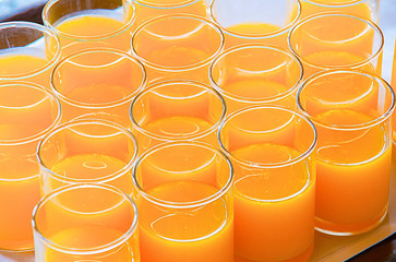 Glasses of orange juice stick together ready to serve