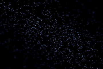 Abstract black glitter texture on a black background. Gold shiny