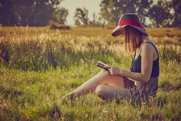Giovane ragazza legge un libro in campagna