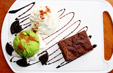 dessert made of brownie and green tea ice cream together with whipped cream on the white plate