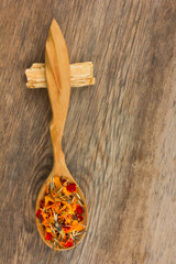 marigold petals in a wooden spoon on the old board in the cracks. view from above close-up