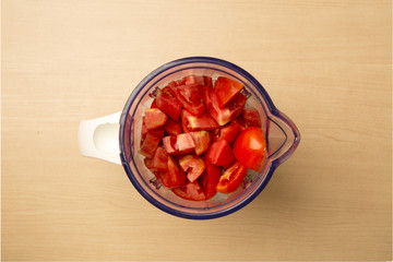 Fresh tomato and blender, view from above
