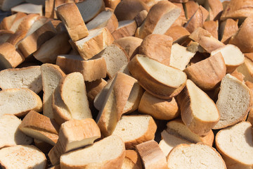 a lot of pieces of wheat bread loaf laid out in a pile on the sun