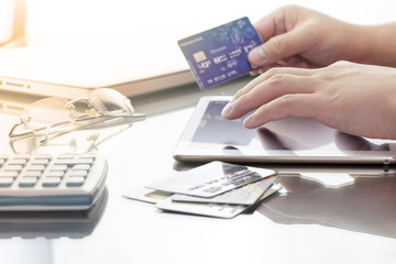 Man using his digital tablet while holding a credit card intent to online shopping, concept with digital business or e-commerce concept. close up, warm tone.