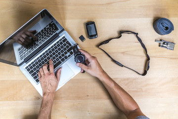 Elevated view of desk with hands, laptop, sports watch, chest strap and gps device