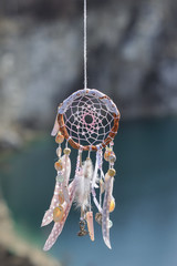 Handmade native american dream catcher on background of rocks an