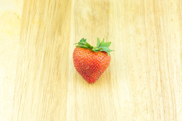 Red berry strawberry isolated on wood background