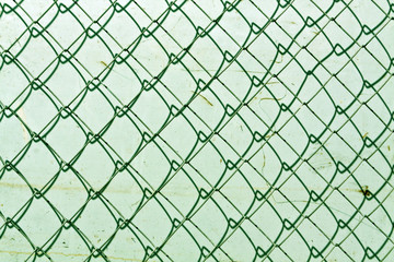Fototapeta premium abstract chain link fence texture against grungy color wall.