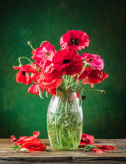 Fototapeta premium Bouquet of poppy flowers in the vase on the wooden table.