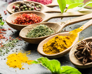Assortment of colorful spices in the wooden spoons.