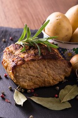 Baked piece of pork meat on slate stone