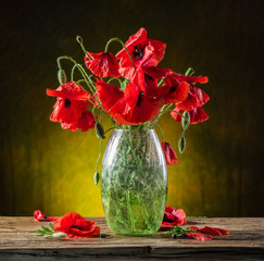 Naklejka na ściany i meble Bouquet of poppy flowers in the vase on the wooden table.