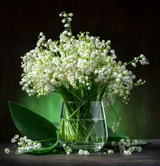 Rucksack Lily of the valley bouquet on the wooden table. © volff