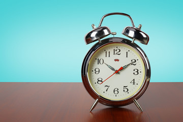 Old retro alarm clock on a wooden table