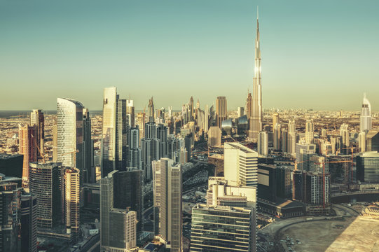 Fantastic architectural background. Panoramic Dubai cityscape with skyscrapers at sunset. Scenic travel background.
