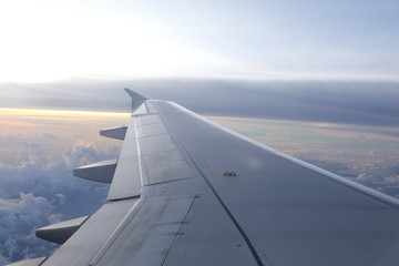 Fototapeta na wymiar wing of airplane on sunset sky