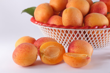 Cut apricot on background heap of apricots in a bowl