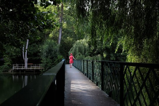 Woman walking along treetop walkway, Niort, France