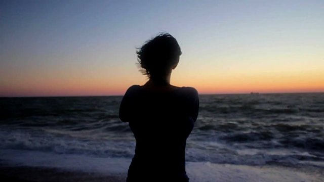 Woman taking photo on the beach. Handheld shot