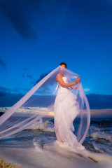 Naklejka premium bride on a tropical beach at sunset