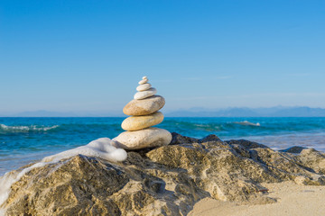 Stones pyramid on sand symbolizing zen, harmony, balance. Ocean