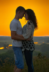 romantic couple at sunset on bright yellow sky background, love