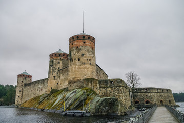 Fototapeta premium Olavinlinna fortress and Kuussalmi bay of Lake Saimaa at rainy weather. Savonlinna, Finland.
