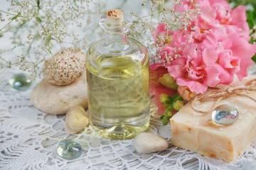Natural handmade soap, aromatic oil and flowers on white wooden