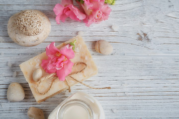 Fototapeta na wymiar Natural handmade soap, aromatic oil and flowers on white wooden