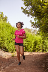 A young girl jogging on a trail