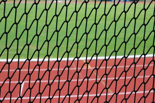 Safety net at a athletic stadium, running tracks and football pitch as a background 