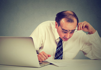 Confused surprised business man looking at documents.