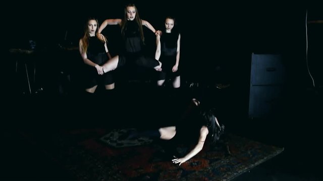 Contemporary dance performance of four dancers on dark