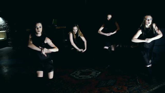 Contemporary dance performance of four dancers on dark