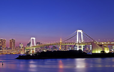Obraz premium Rainbow bridge, located at Odaiba Tokyo, with Tokyo skyline in background at twilight
