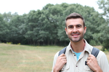 Fototapeta premium Young man hiking smiling happy portrait. Male hiker walking in forest.