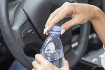Girl in the car with a bottle of clean drinking water.