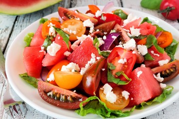 Watermelon and colorful mixed tomato salad with feta cheese close up