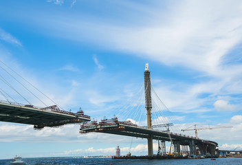 The construction of a cable-stayed road bridge across the river.
